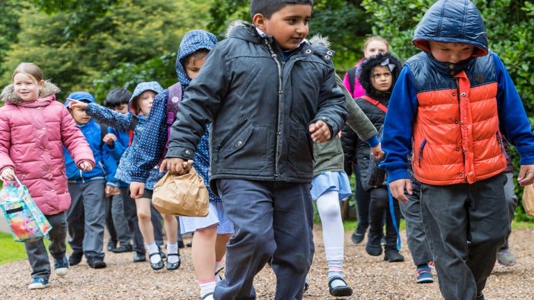 Children in their winter coats, carrying their lunches, on a school trip